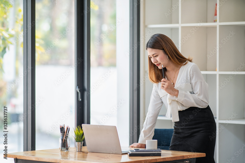 Portrait of young business woman working and thinking in the office Portrait of young business woman working and thinking in the office