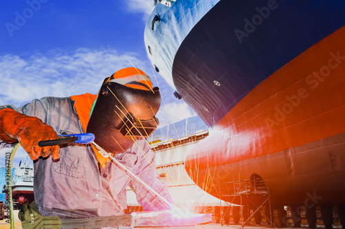 Welder worker industry shipbuilding and ship repair industry at the factory and floating dock in shipyard. photo