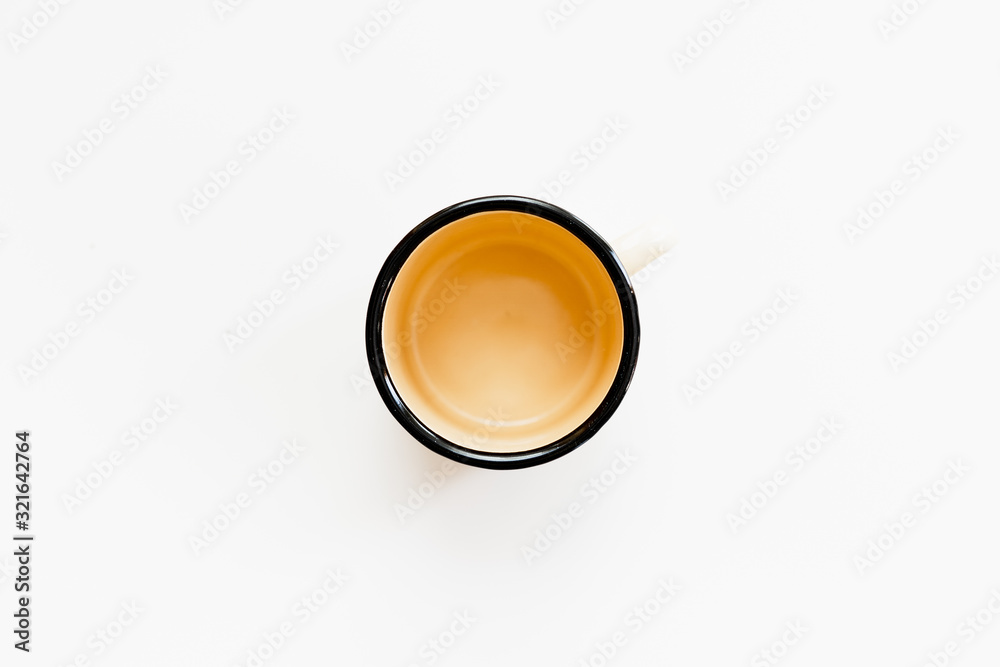 Beige enamel mug isolated on white background. Top shot of tin mug. Beige enamel mug isolated on white background. Top shot of tin mug.