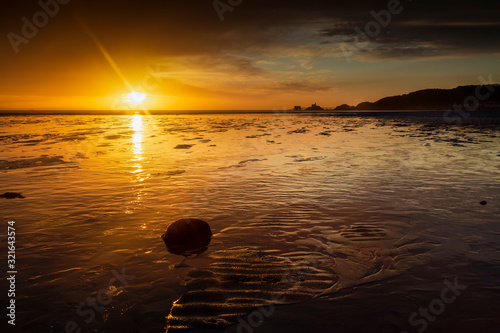 A Winter sunrise over a low tide at Swansea Bay and Mumbles pier, UK