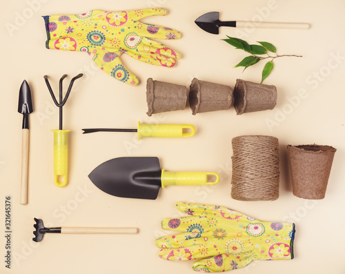 Flat Lay with Garden Tools Gardening Spring or Summer Concept Yellow Gloves Garden Shovel Rake and Thread are Lying on Yellow Background Top View Horizontal