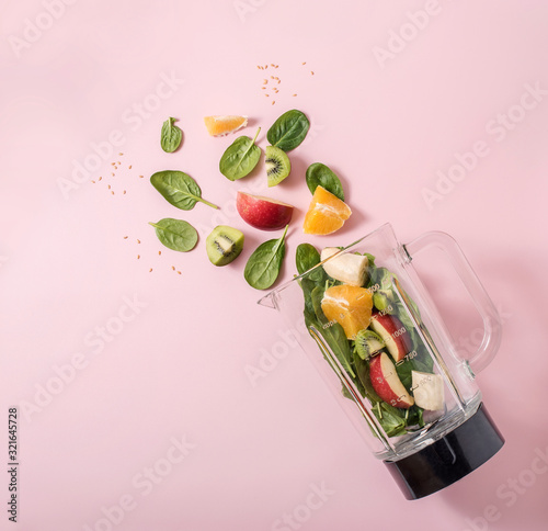 Smoothie ingredients in mixer, smoothie preparation with spinach, apple, orange, kiwi, healthy eating, detox and nutritional consultation concept