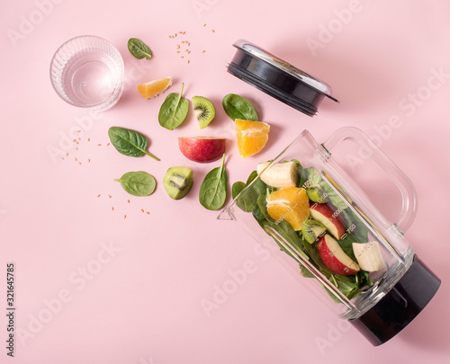 Smoothie ingredients in mixer, smoothie preparation with spinach, apple, orange, kiwi, healthy eating, detox and nutritional consultation concept
