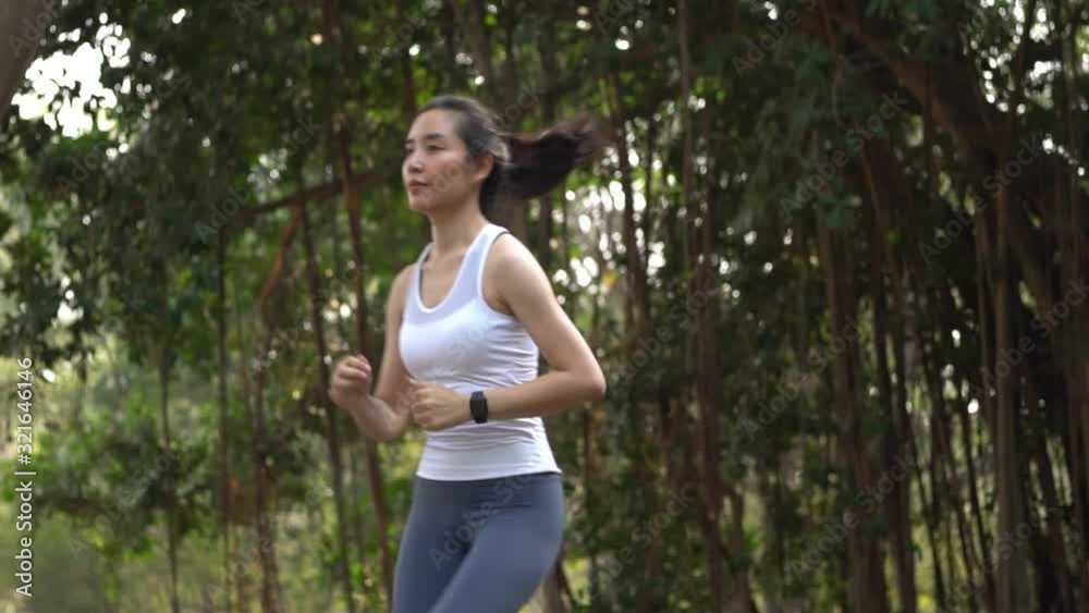 Slow motionteenage woman running in a park during summer day Slow motionteenage woman running in a park during summer day