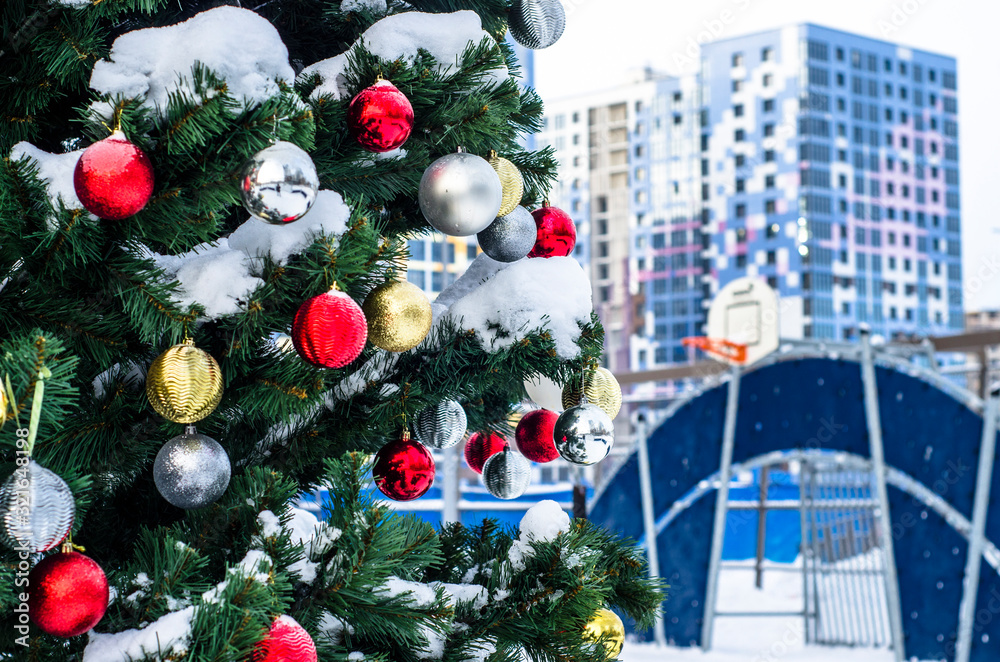 Christmas tree in the courtyard of a high-rise residential complex of increased comfort. Decoration of the public yard for the new year. Modern landscaping of the courtyard of a residential building.