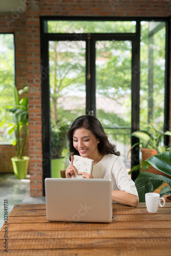 Asian woman working and drink coffee in cafe with laptop computer smile and happy work