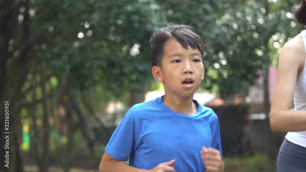Slow motion little Asian boy running with his sister in a park Slow motion little Asian boy running with his sister in a park