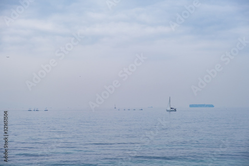 Hazy view of sailing boats off the coast in Paleo Faliro in Athens, Greece © Iordanis Pallikaras