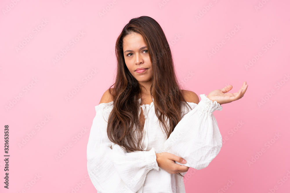 Young Brazilian girl over isolated pink background unhappy for not understand something Young Brazilian girl over isolated pink background unhappy for not understand something
