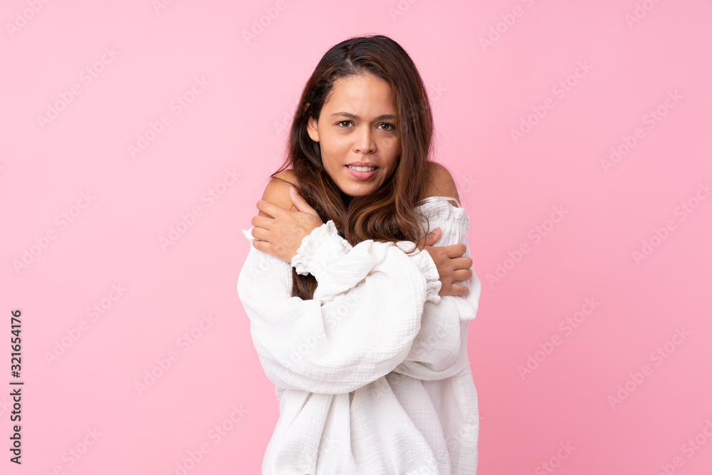 Young Brazilian girl over isolated pink background freezing Young Brazilian girl over isolated pink background freezing