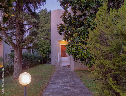 Athens Greece, stone path through the garden to elegant house entrance, night view