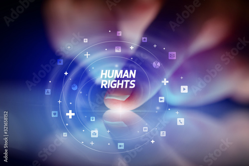Finger touching tablet with social media icons and HUMAN RIGHTS