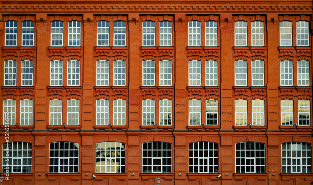 Orange-red architectural facade of the building with large windows