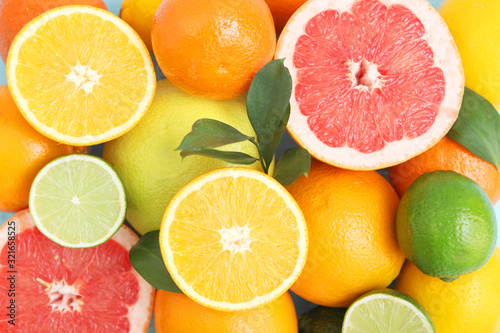 Fototapeta Naklejka Na Ścianę i Meble -  Different citrus and juicy slices on a colored background top view. Place to insert text.