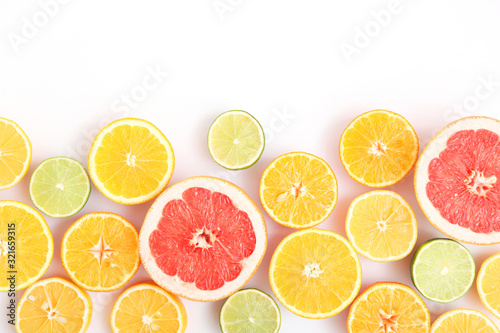 Different citrus and juicy slices on a light background top view. Place to insert text.