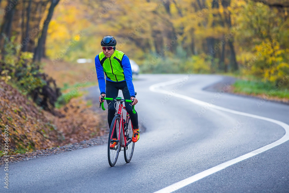 young man in bikers clothes riding a racing bicycle young man in bikers clothes riding a racing bicycle