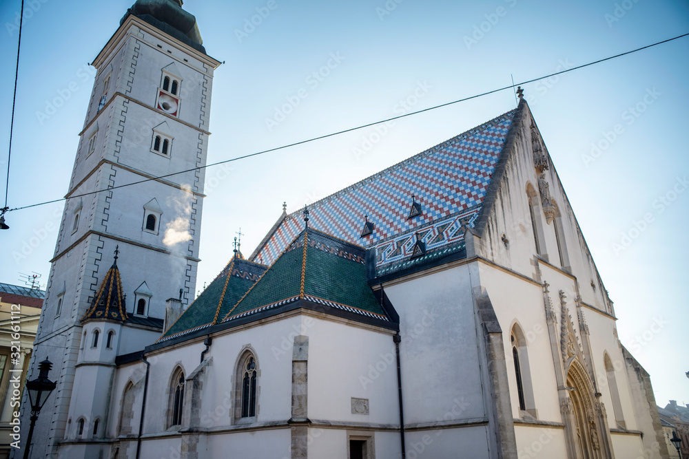 Obraz premium side view of the colorful St. Mark church at a cloudy day with a christmas tree at Zagreb, Croatia