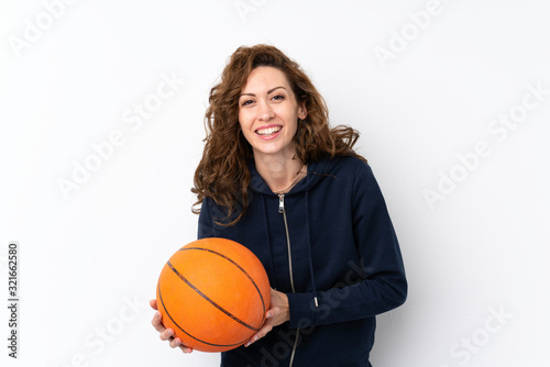 Young pretty woman over isolated background with ball of basketball