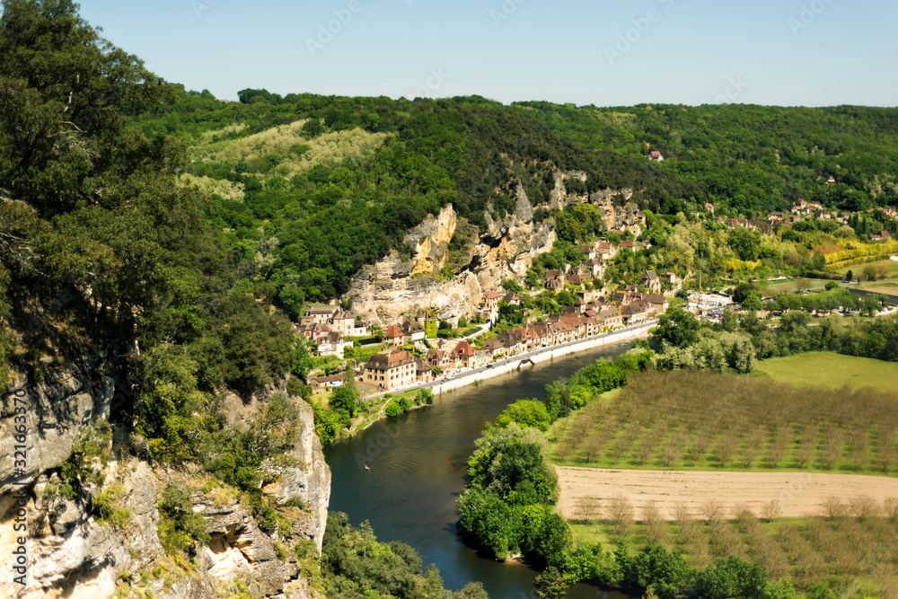 View of one of most beautiful villages of France La Roque-Gageac, Dordogne, Aquitaine from Marqueyssac gardens. Countryside french landscape with Dordogne river, fields and hills. Travel destination.