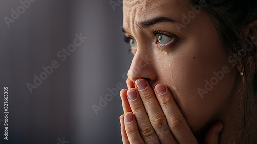 Leinwand Poster Sad unhappy grieving crying woman with tears eyes closeup
