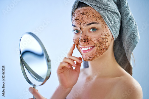 Fotografie, Obraz Smiling happy woman in bath towel with natural face coffee scrub mask after show