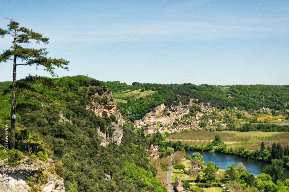 View of one of most beautiful villages of France La Roque-Gageac, Dordogne, Aquitaine from Marqueyssac gardens. Countryside french landscape with Dordogne river, fields and hills. Travel destination.