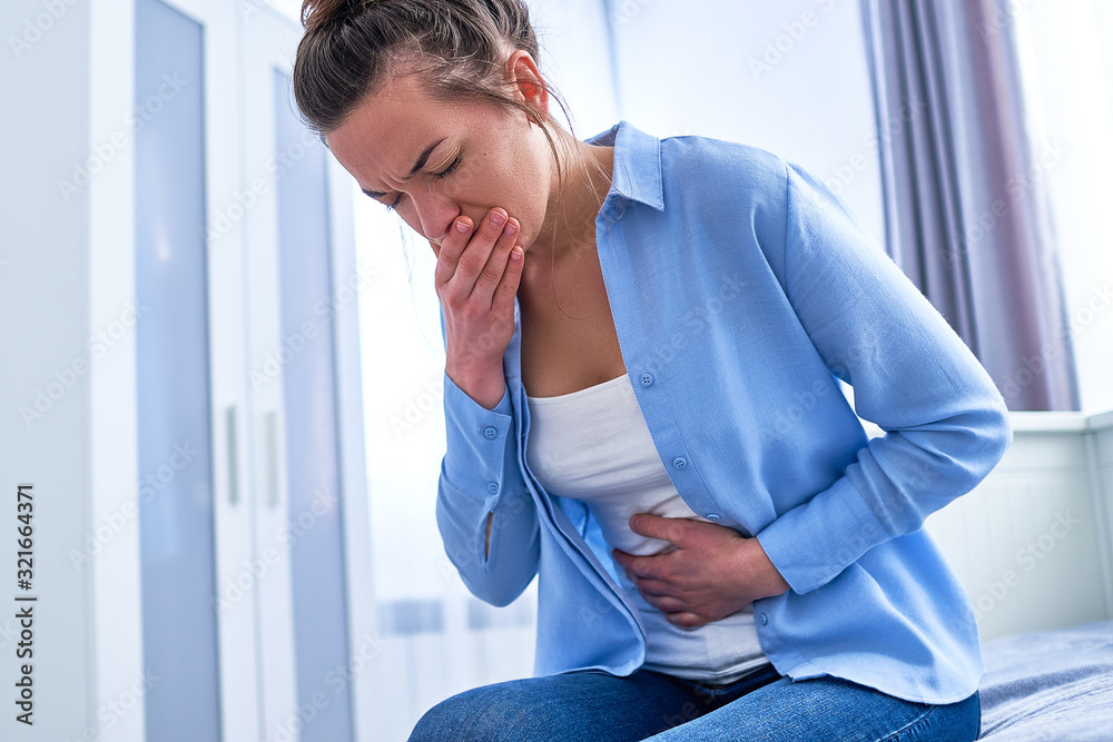 Foto de Young woman suffers from nausea and vomiting due to digestive