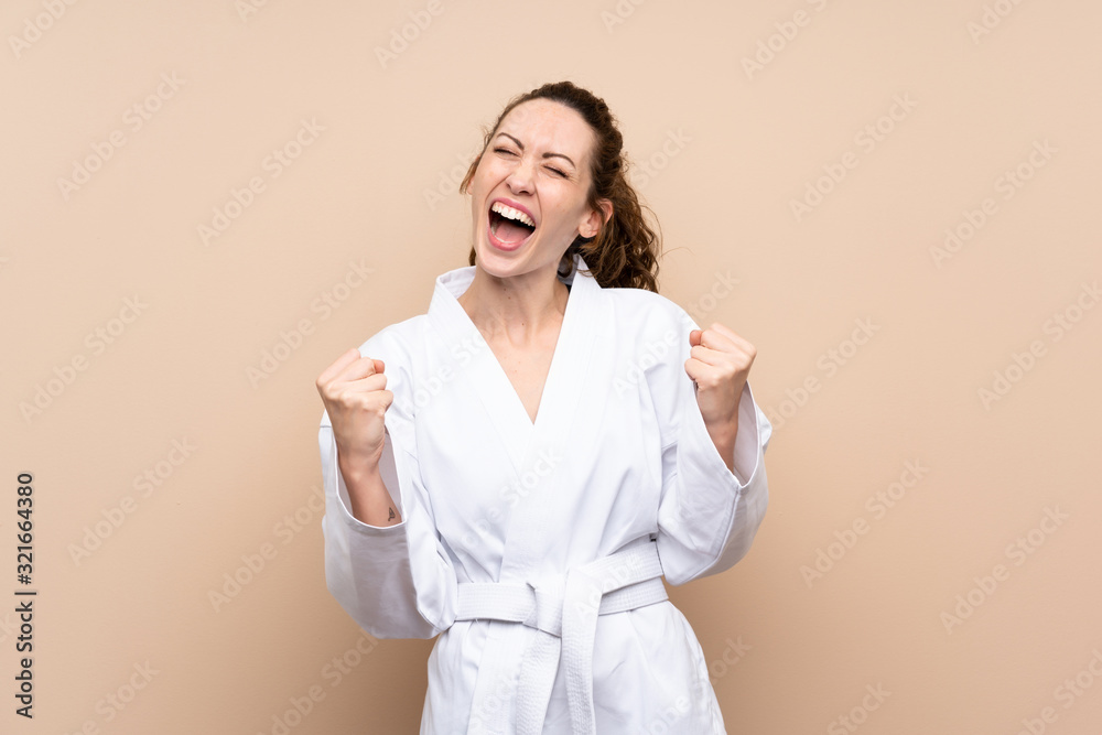 Young woman doing karate over isolated background Young woman doing karate over isolated background
