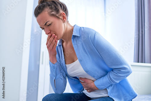 Woman suffers from nausea and vomiting during gastrointestinal system disease or food poisoning, health problems photo