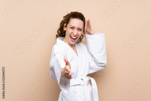 Young woman doing karate over isolated background