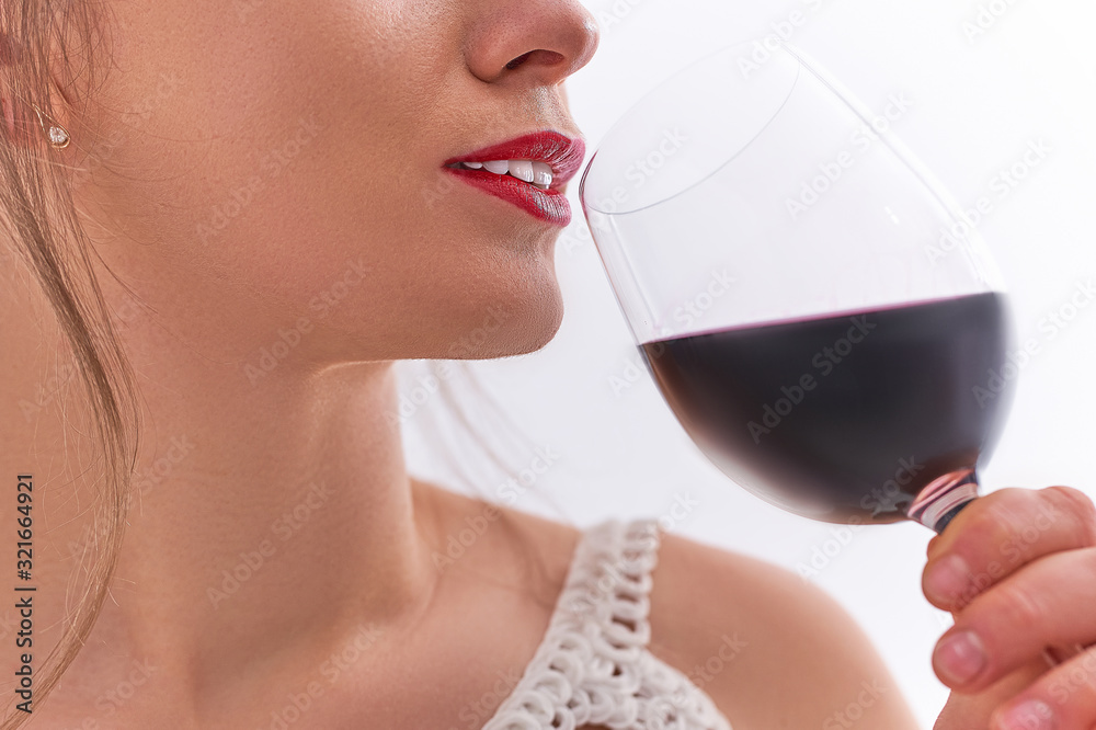 Drinking woman with red lips enjoys a glass of dry red wine close up Drinking woman with red lips enjoys a glass of dry red wine close up