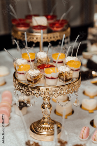 Dessert table for a party. Desserts doused with jam, cupcakes. Candy bar. Dessert at a wedding or catering event © Tetiana Moish