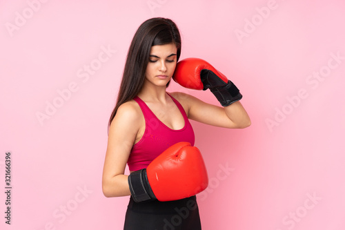 Young sport woman over isolated pink background with boxing gloves