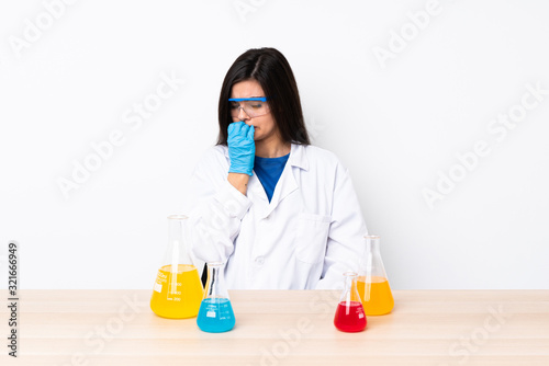 Young scientific woman in a table having doubts