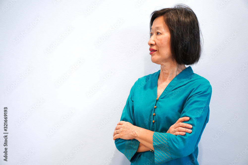 An old beautiful asian woman with smiling face in blue blouse on the white background An old beautiful asian woman with smiling face in blue blouse on the white background
