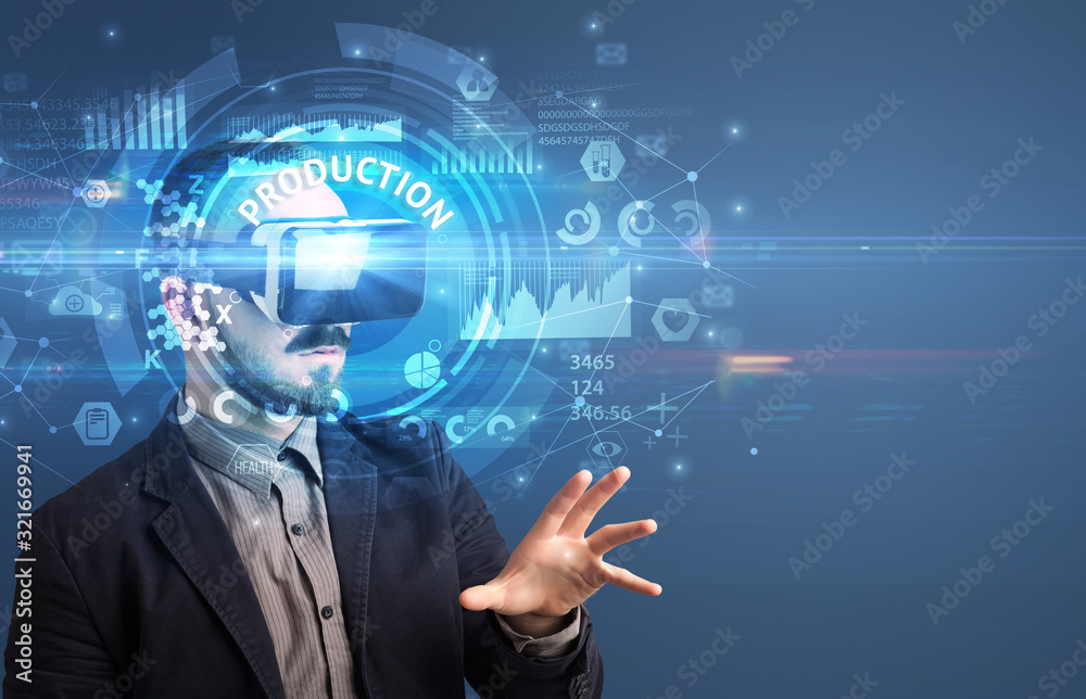 Businessman looking through Virtual Reality glasses with PRODUCTION inscription, innovative technology concept Businessman looking through Virtual Reality glasses with PRODUCTION inscription, innovative technology concept