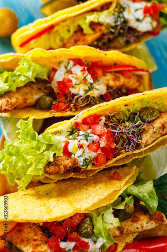 Tacos, corn tortilla tacos with grilled chicken meat and fresh vegetables with addition aromatic and spicy herb 