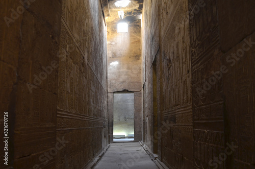 The Temple of Edfu is an Egyptian temple located on the west bank of the Nile in Edfu. It's considered to be one of the most beautiful and preserved Temples in Egypt. Beautiful passage with sunlight