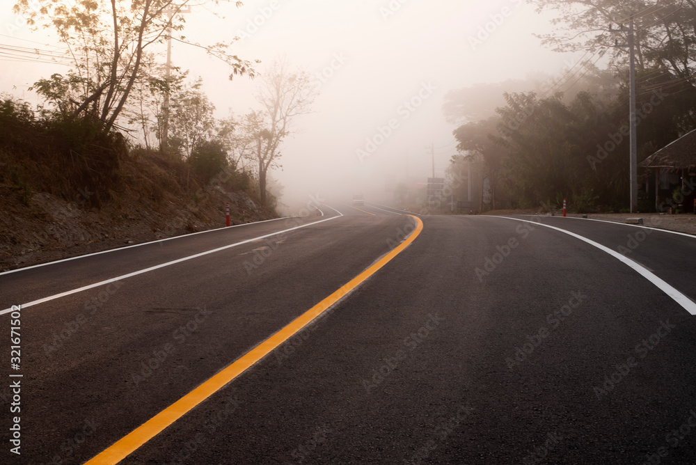 The sun shines down on the roads in the tropical forests of Asia. The road is full of haze in the morning time.