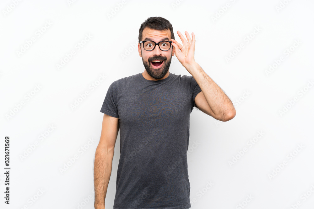 Fototapeta premium Young handsome man over isolated white background with glasses and surprised