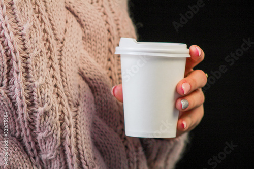 woman holding a cup of coffee in front of her face