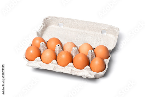 ten brown chicken eggs in a cardboard tray on a white background