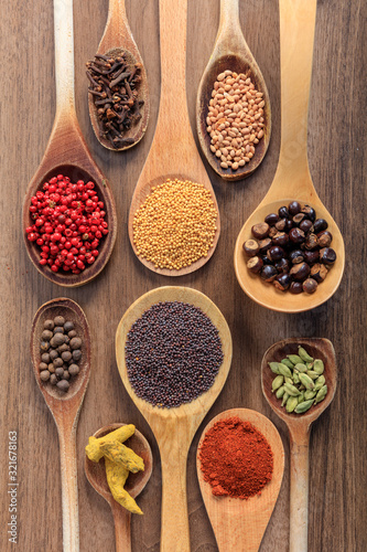 Spices and herbs flat lay, wood background, top view.
