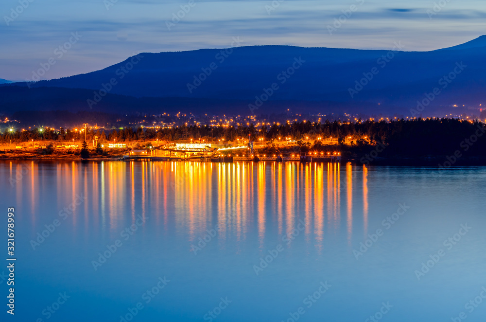 Tranquil sunset and evening illuminations of the beautiful town of Nanaimo on Pacific Ocean in Vancouver, Canada.