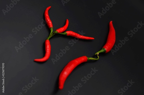 Small red peppers on a black background