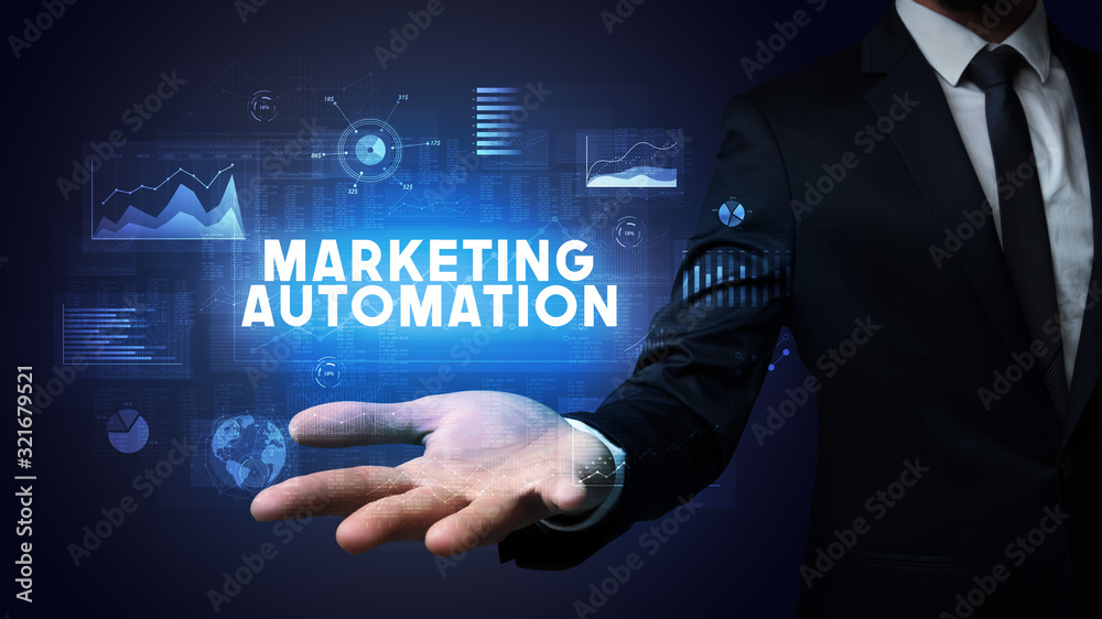 Hand of Businessman holding MARKETING AUTOMATION inscription, business success concept