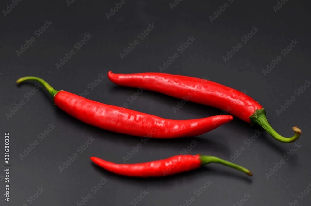Red peppers on a black indoor background