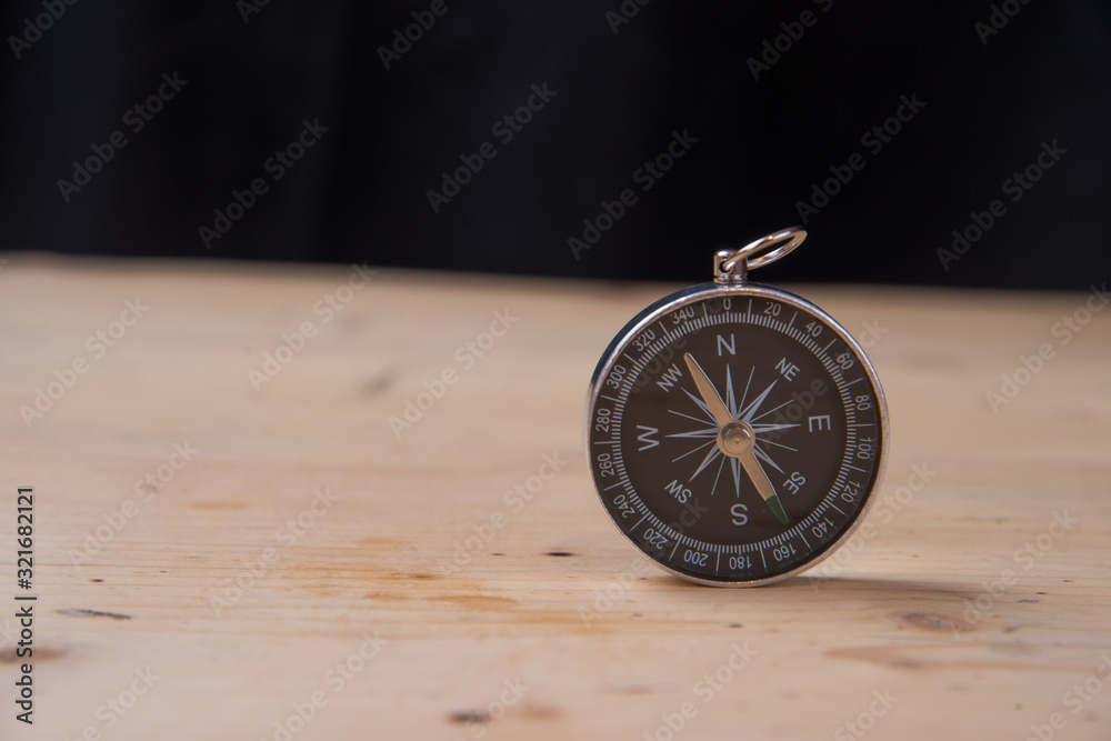 The concept of travel and adventure. Compass on wooden base The concept of travel and adventure. Compass on wooden base