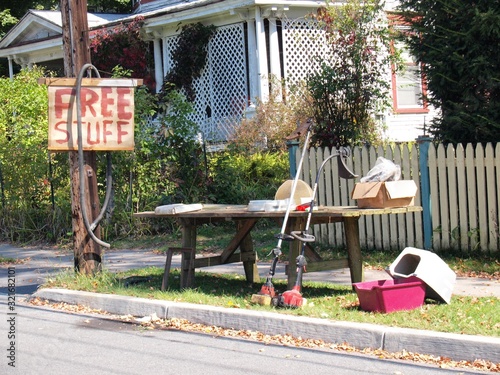 A Free Stuff sign with yard sale leftovers by the curb