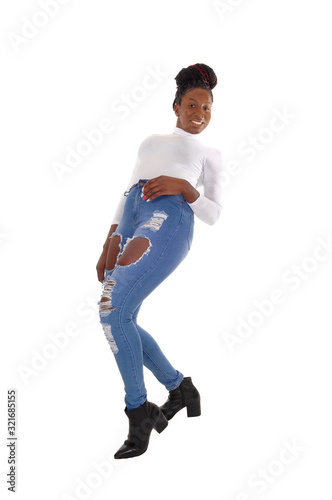 Beautiful tall woman standing in ripped jeans in the studio
